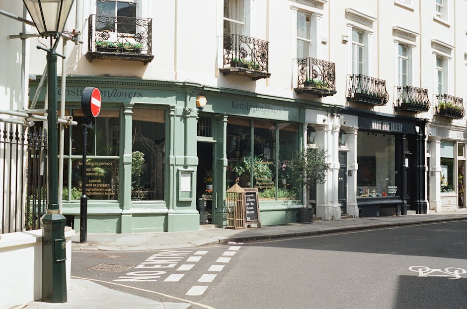 A cobbled residential street in South Kensington with rows of multi-storey houses on either side, featuring a mix of modern and traditional architecture. The buildings have different exterior finishes
